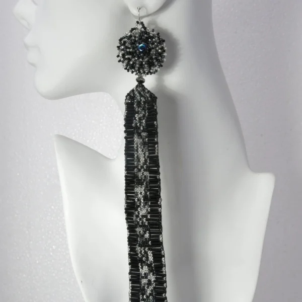 Woman wearing elegant handcrafted black and white seed bead earrings and matching ring.