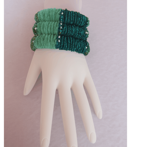 Teal beaded cuff bracelet worn on mannequin hand